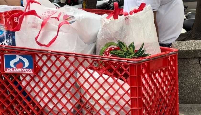 Comprador transporta su compra con bolsas de tela.