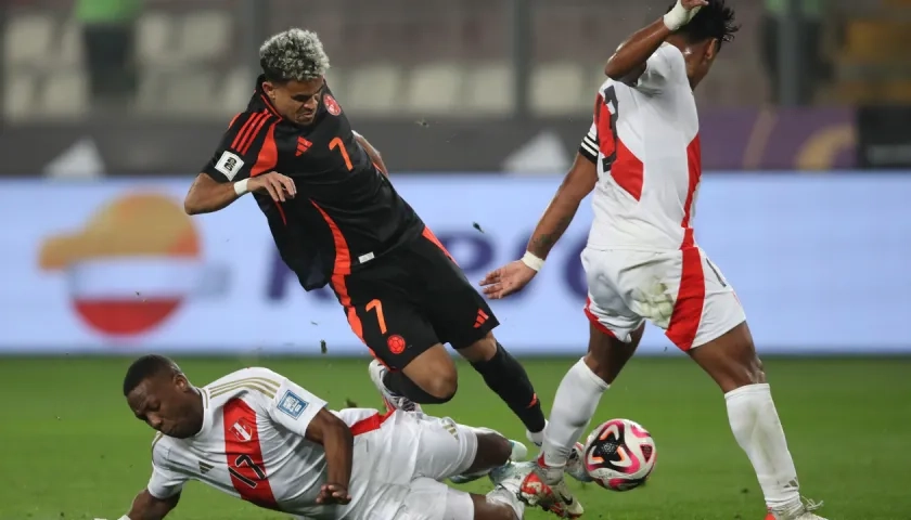 Luis Díaz es trabado por Luis Advíncula durante el partido en Lima. 