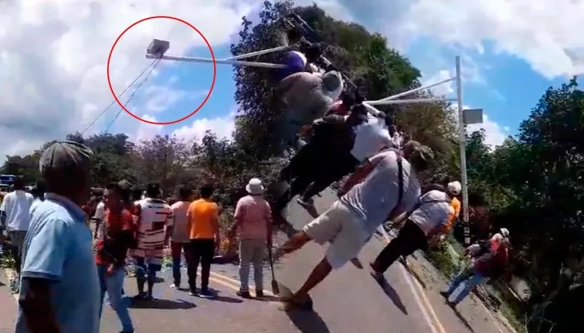 Momento en que los manifestantes tumbaron la cámara de fotomultas. 