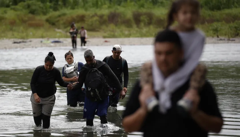 Migrantes cruzando el río Tuquesa luego de atravesar la selva del Darién, en Panamá.