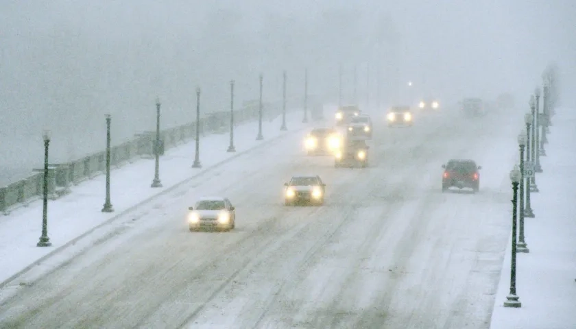 Vehículos avanzando en medio de la nieve en el Puente Memorial de Arlington que conecta a Virginia con Washington.