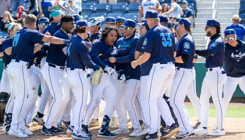 El colombiano Michael Arroyo es felicitado por sus compañeros tras llegar al plato. 