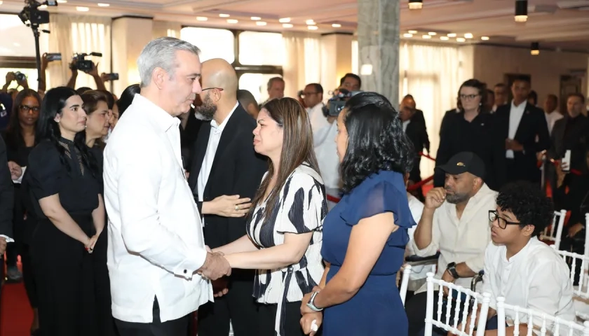 Zulinka Pérez, hija de Rubby Pérez, recibiendo las condolencias del presidente dominicano Luis Abinader. 
