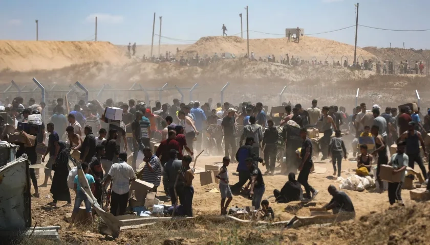 Palestinos transportan suministros de ayuda recibidos de la Fundación Humanitaria de Gaza.