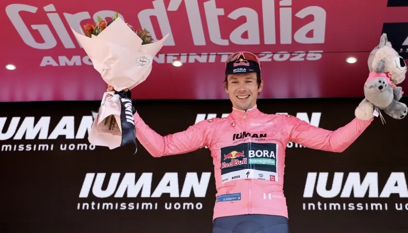 Primoz Roglic vestido en el podio con la maglia rosa. 