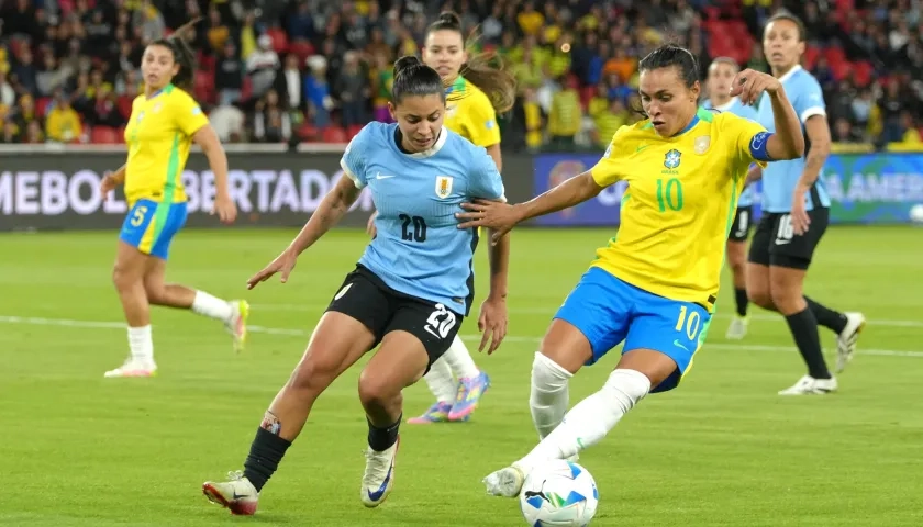 Marta, de Brasil, disputa el balón con Angela Gómez, de Uruguay.