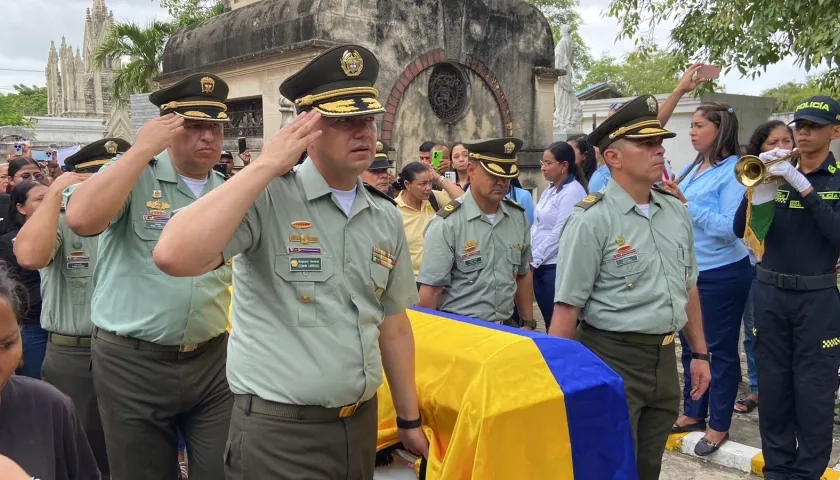 Féretro siendo cargado por uniformados de la Policía.