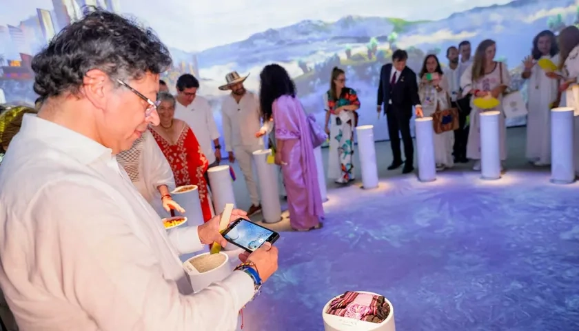 El Presidente Gustavo Petro tomando una imagen una lechona.