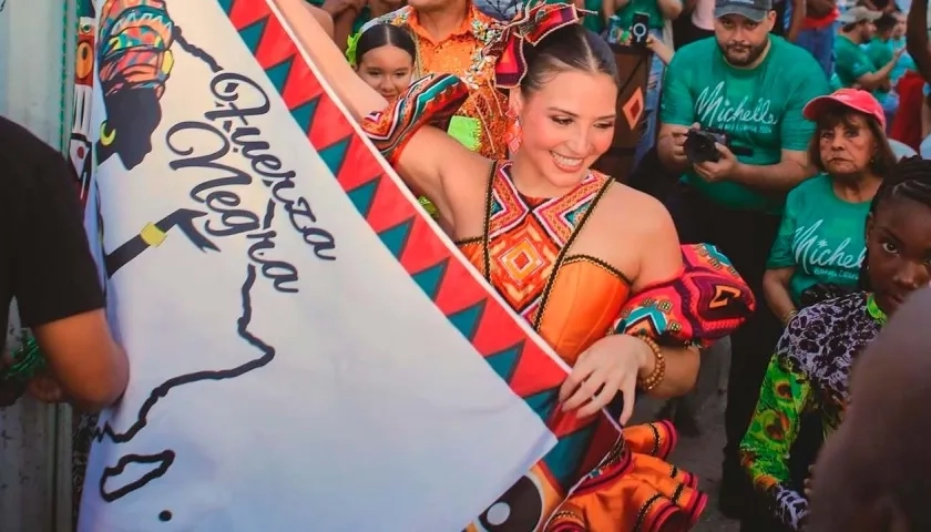 La Reina Michelle izando la bandera del grupo 'Fuera negra'. 