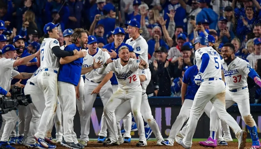 Freddie Freeman es esperado en el plato por sus compañeros para celebrar.