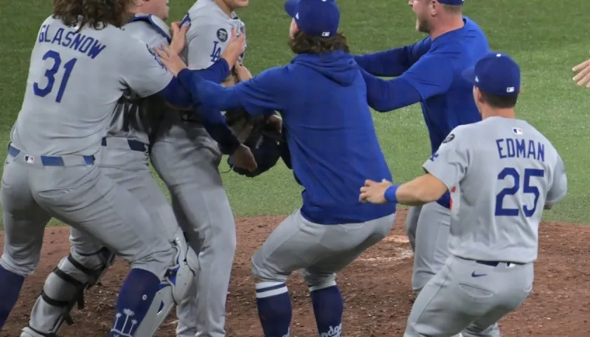 El lanzdor japonés Yoshinobu Yamamoto, Jugador Más Valioso de la Serie Mundial, es felicitado por sus compañeros al concluir el juego.