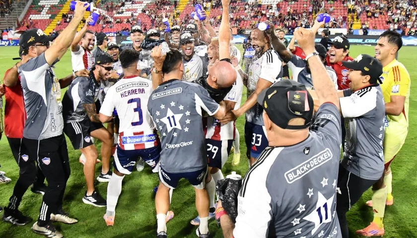El técnico del Junior, Alfredo Arias, celebra el título con sus jugadores.