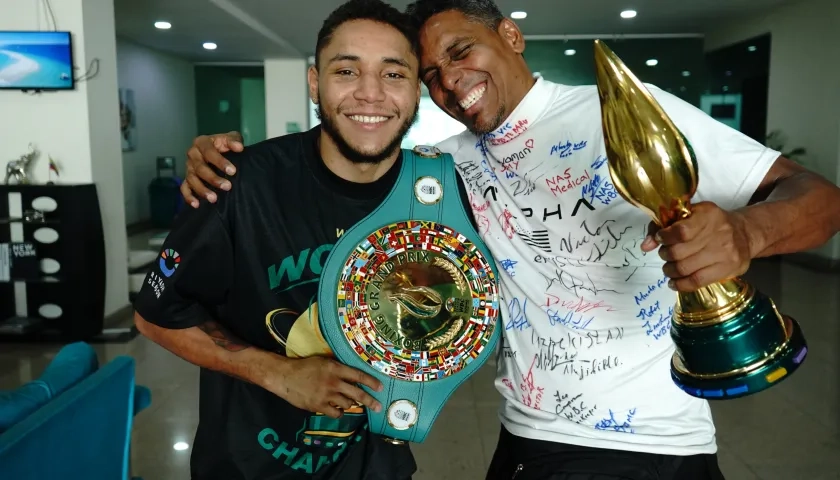 Carlos Utria con el cinturón de campeón y su papá y entrenador Lenin 