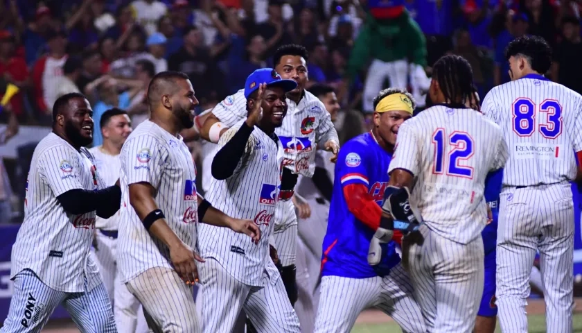 Carlos Arroyo (12) es felicitado por sus compañeros tras darle la victoria a Caimanes con un jonrón. 