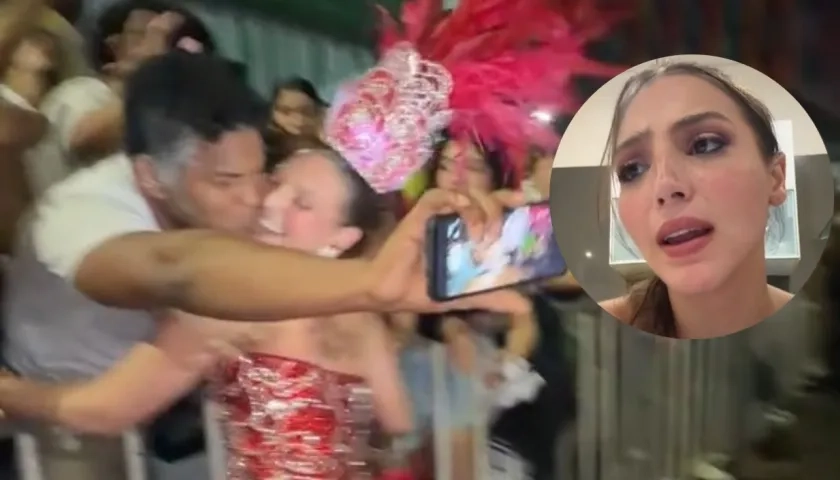 Momento del beso y la imagen de la Reina.