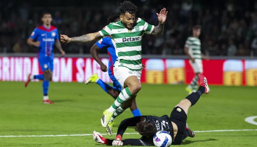 El portero del Alverca André Gomes trata de frenar al delantero del Sporting Luis Suárez.