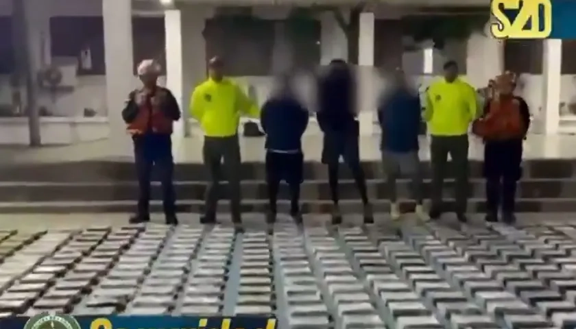 Las autoridades junto a parte de lo incautado y los tres capturados.