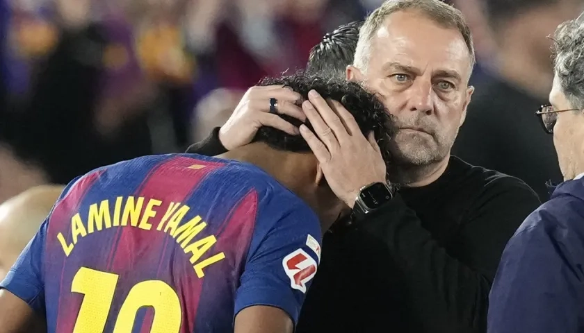 Lamine Yamal, autor del gol del Barcelona, es consolado por el técnico Hansi Flick tras salir de la cancha por lesión.