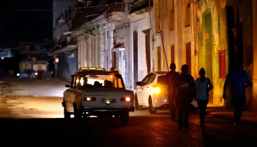 Personas caminan por un sector sin servicio eléctrico en La Habana. 