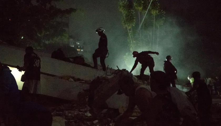  Integrantes de cuerpos de emergencia buscan víctimas entre escombros
