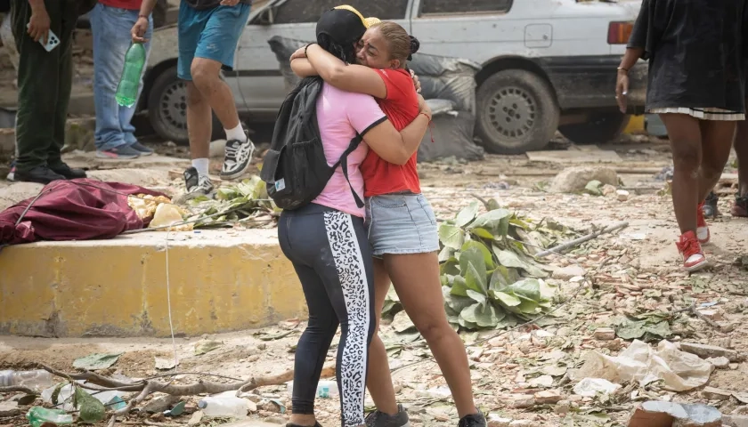 Personas lloran frente a escombros de edificios afectados por los terremotos 