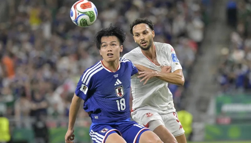 Ayase Ueda, autor de un dobleta para Japón, disputa el balón con Montassar Talbi.