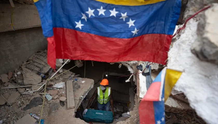 Una persona realiza labores de búsqueda entre los escombros de edificios destruidos por terremotos en La Guaira. 