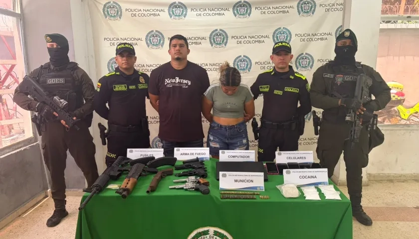 La pareja capturada junto con el arsenal de guerra incautado. 