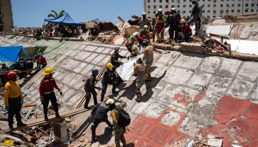 Rescatistas buscan cuerpos entre los escombros.