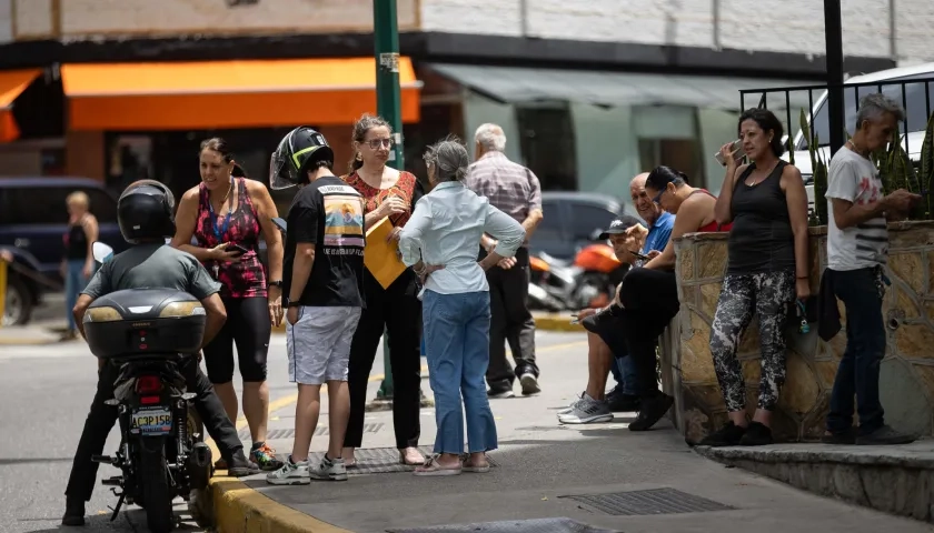Personas esperan afuera de sus viviendas este viernes. 