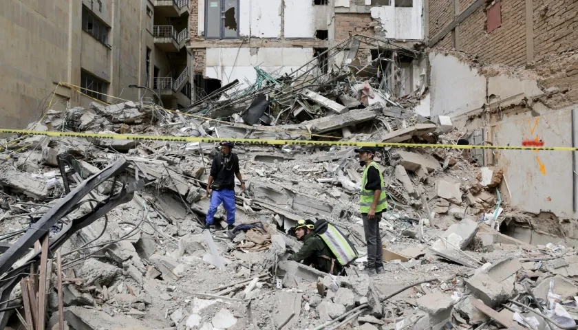 Personas observan los escombros de un edificio afectado por el terremoto en Pereira. 