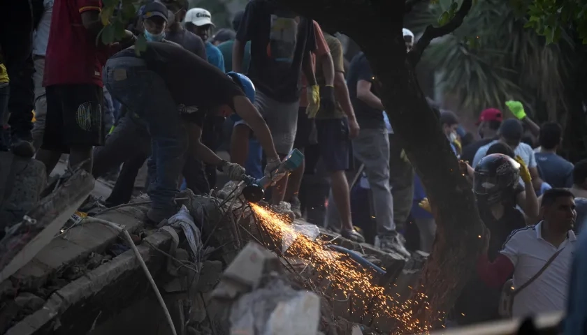 Voluntarios trabajan en labores de rescate en una edificación colapsada 