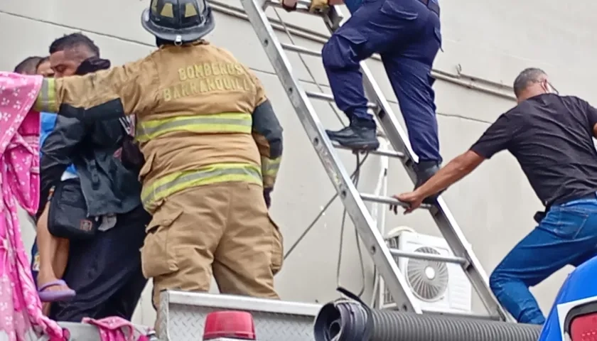 Bomberos con escaleras rescatando pacientes en el tercer piso