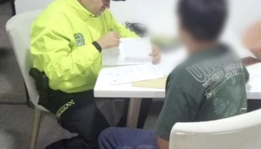 La Policía leyendo la orden de captura contra el señalado de las amenazas. 