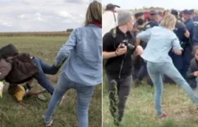 Momentos en que la periodista Petra László puso zancadillas a varios refugiados.