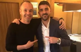Andrés Iniesta recibiendo a David Villa. 
