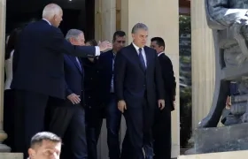 El presidente de Colombia, Iván Duque (c), sale de la Academia Colombiana de la Lengua, lugar de velación del expresidente Belisario Betancur