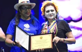 La Gerente de la empresa Carnaval, Carla Celia, entregando el reconocimiento a la hija de Efrain Mejía.