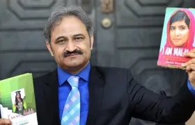 El presidente de la Federación de Colegios Privados de Pakistán, Mirza Kashif Ali, muestra un par de libros, uno de ellos escrito por la Premio Nobel de la Paz, Malala Yousafzai.