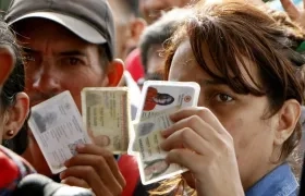 Una mujer venezolana muestra sus documentos.