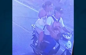 La mujer cuando iba en una moto con la bebé en un maletín.