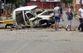 Ciudadanos pasan frente a un coche quemado, en la ciudad de Masaya