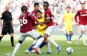 El volante del Chelsea, Eden Hazard, frenado por defensores del West Ham. 