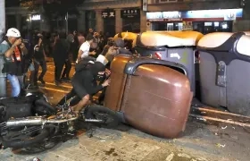 Varios manifestantes vuelcan contenedores en Barcelona.