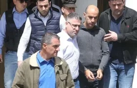 Nikos Metaxas es llevado esposado a la corte.