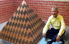 Cory Nielsen, de 55 años, junto a su pirámide nombrada "Cooper Beast" (Bestia de cobre) que creó con 1.030.315 monedas de un centavo de dólar.
