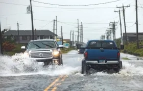 Dos carros en medio del agua transitan por Carolina del Norte.