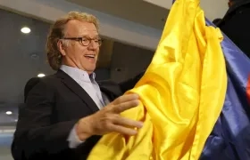 El violinista de Países Bajos André Rieu enarbola este lunes una bandera colombiana tras arribar al Aeropuerto Internacional El Dorado, en Bogotá (Colombia).