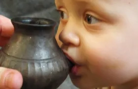 Bebé actual alimentado a partir de un recipiente reconstruido a semejanza del que se describe en el estudio de Nature.