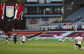 Jugadores de rodillas antes del inicio de un partido. 